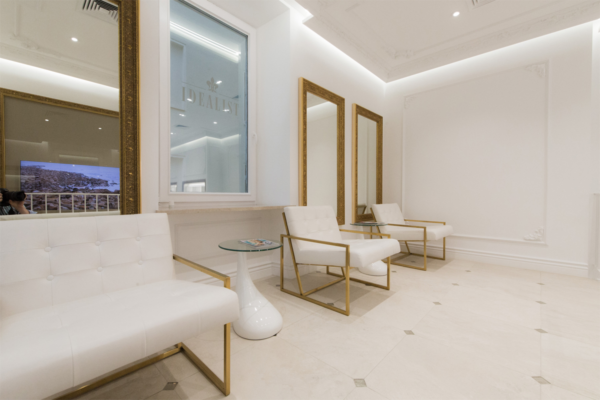 Wartebereich eines Beauty-Salons mit gemütlichen Stühlen in weiß und gold